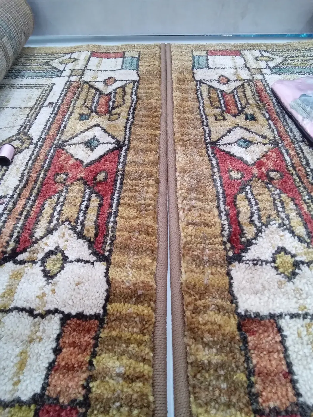Close detail of the pile and border pattern of two rugs