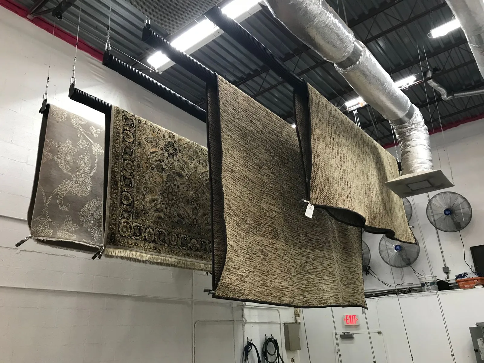 Rugs hanging overhead to air dry