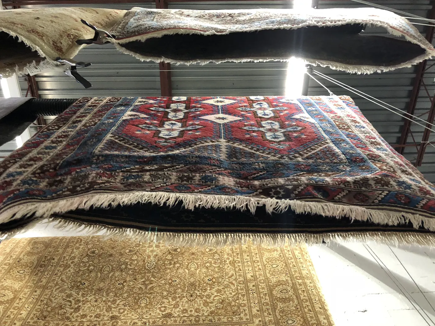 Tribal rug laid over another rug showing the edge and fringe