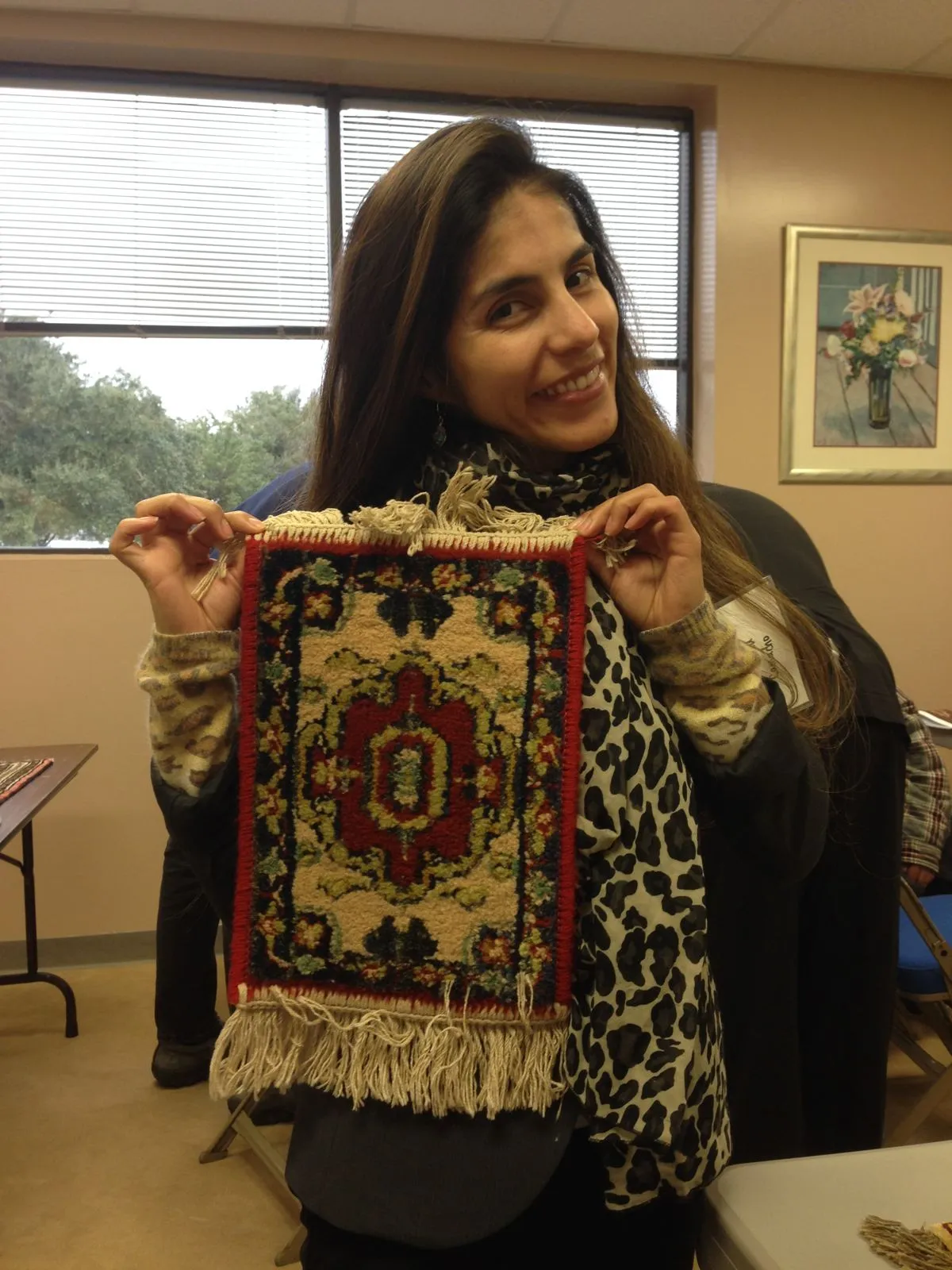 Team member holding a finished small Oriental rug